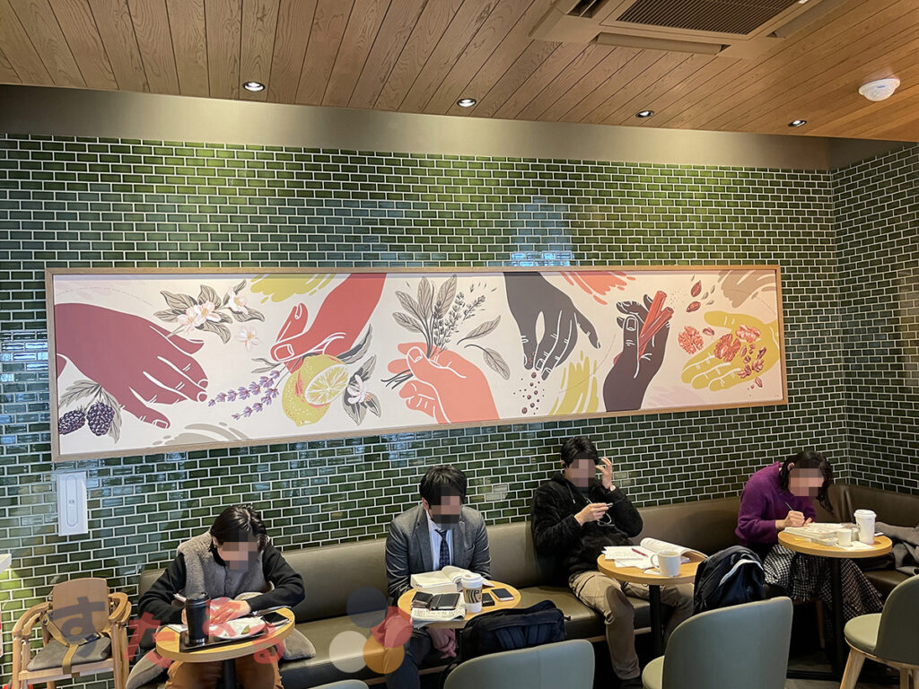 スターバックスコーヒー 名古屋鳴海店の緑レンガの壁に飾られてある巨大なイラストアートの写真