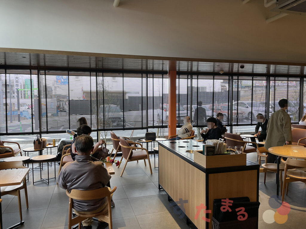 スターバックスコーヒー 名古屋鳴海店の店舗奥緑レンガの壁側から大きな窓ガラスを見た写真