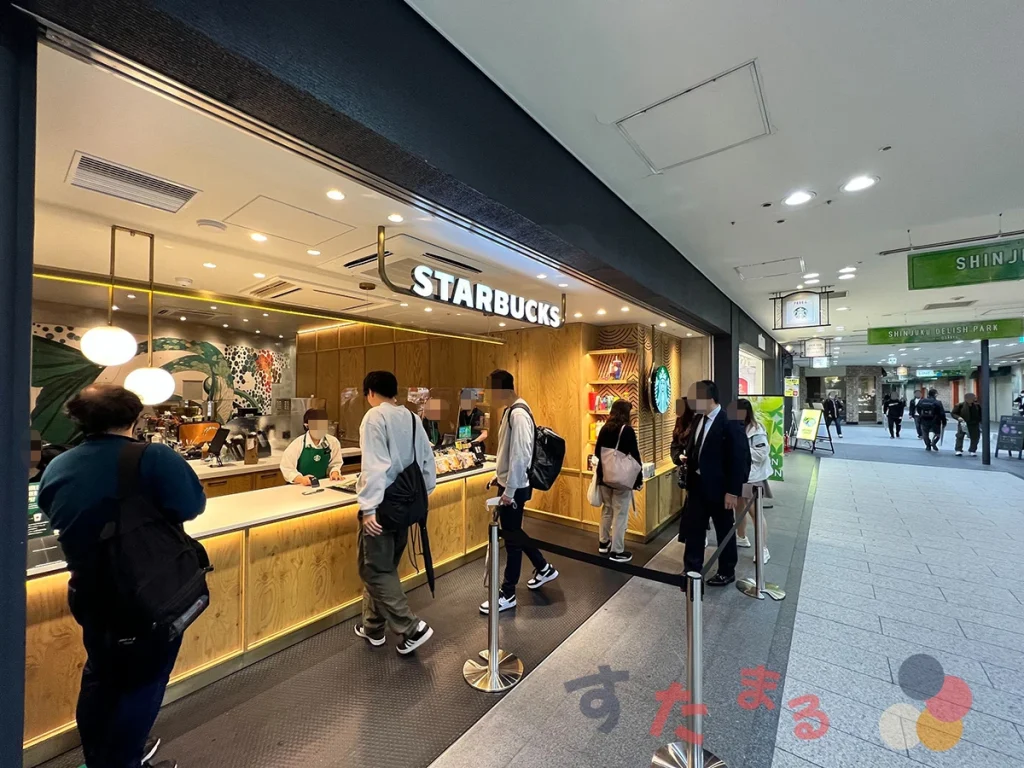スターバックスコーヒー 小田急百貨店SHINJUKU DELISH PARK店の外観をJR新宿駅方面とともに見た写真