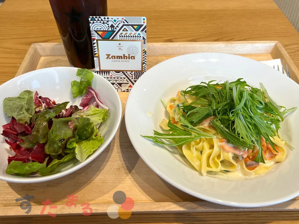 プリンチの月替わりパスタスモークサーモンと水菜のクリームソースタリアテッレとランチプレートに付属するミニサラダの写真