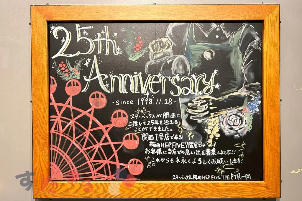 スターバックスコーヒー梅田ヘップファイブ７階店に掲出されている２５周年記念イラストアートが描かれたオファリングボードの写真
