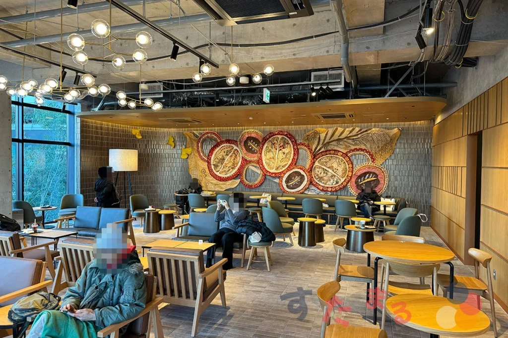 starbucks coffee 都立明治公園店の店内２階の客席と奥の壁に飾られているテキスタイルアートの写真