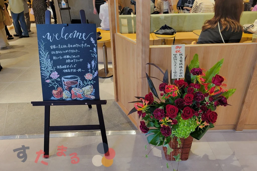スターバックスコーヒー 阪急西宮ガーデンズ4階店のウェルカムボードとオープを祝う花の写真