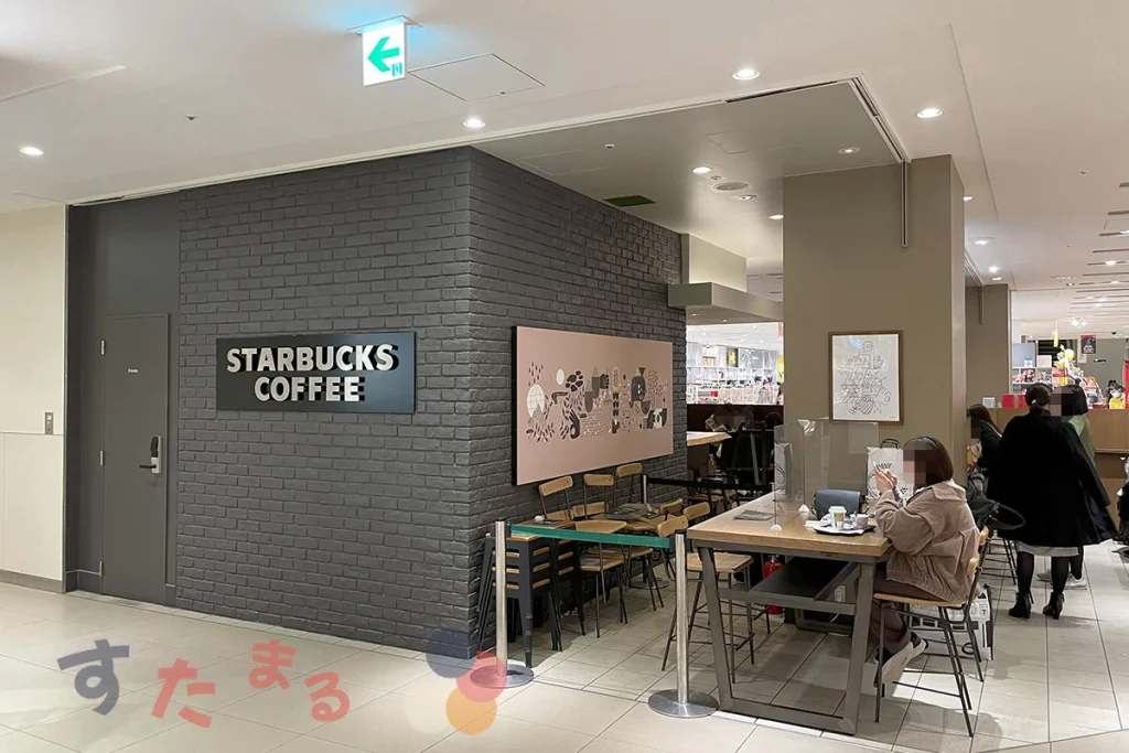 スターバックスコーヒーLUCUA9階店の店舗側面のロゴ文字プレートと客席エリアの写真